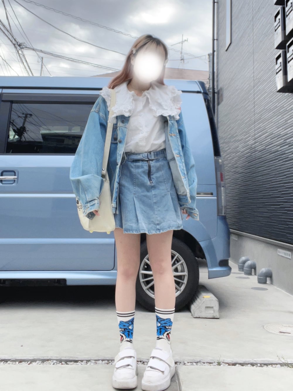 ホワイト系のスニーカー、ブルー系のデニムスカート、ホワイト系のショルダーバッグを着用したレディースの春コーディネートの2枚目の写真