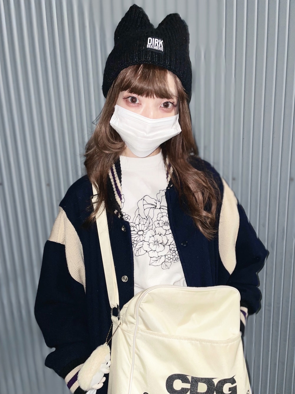 ホワイト系のショルダーバッグ、ブルー系のデニムスカート、ブルー系のスタジャンを着用したレディースの秋コーディネートの4枚目の写真