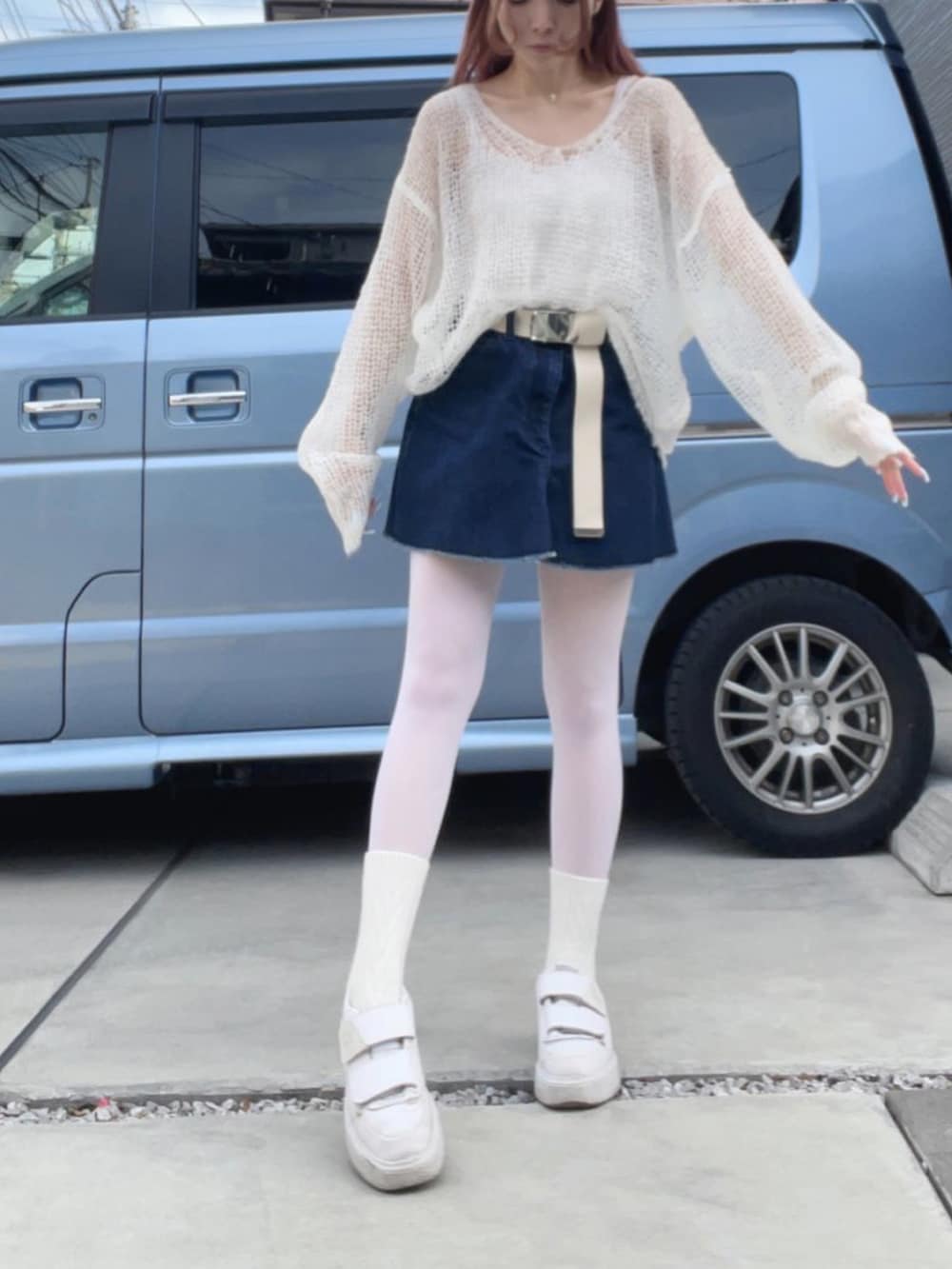 ホワイト系のスニーカー、ブルー系のデニムスカート、ホワイト系のニット/セーターを着用したレディースの冬コーディネートの4枚目の写真