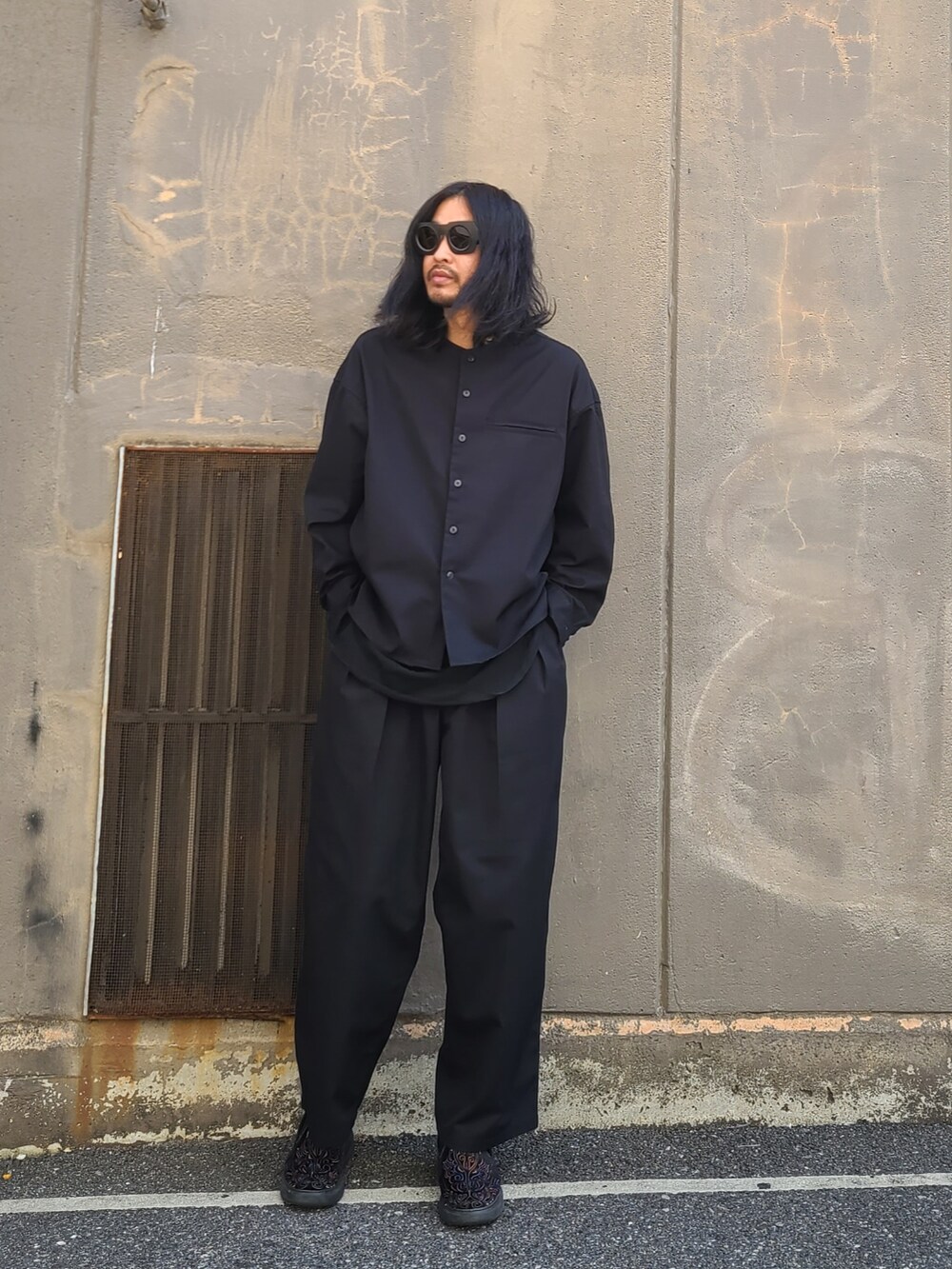 ブラック系のノーカラージャケット、ブラック系のパンツを着用したメンズの春コーディネートの4枚目の写真