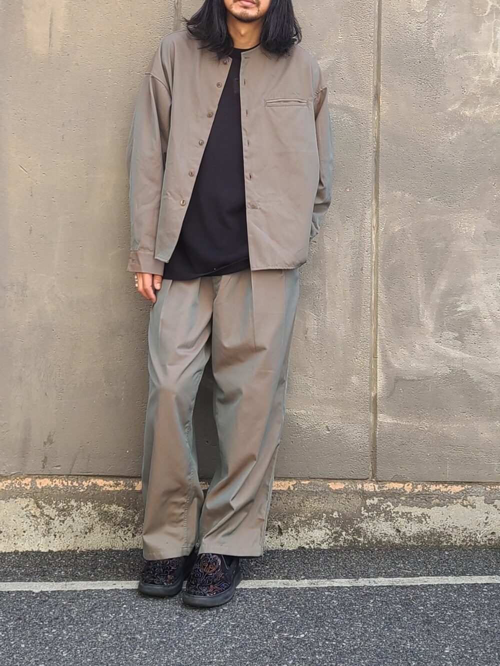 グリーン系のノーカラージャケット、グリーン系のパンツ、シルバー系のリングを着用したメンズの春コーディネートの4枚目の写真