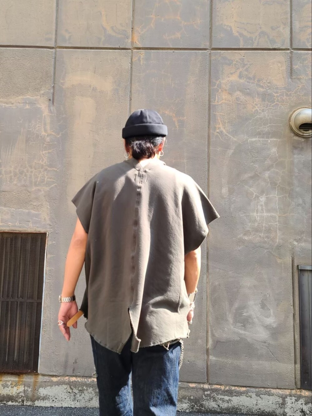 グリーン系のTシャツ/カットソー、ブルー系のデニムパンツ、ブラック系の帽子を着用したメンズの夏コーディネートの3枚目の写真