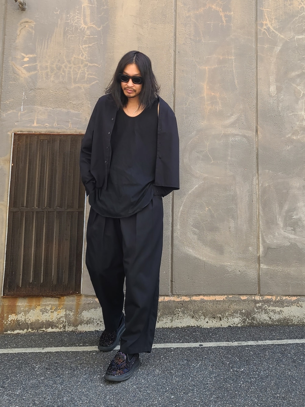 ブラック系のノーカラージャケット、ブラック系のパンツを着用したメンズの春コーディネートの3枚目の写真