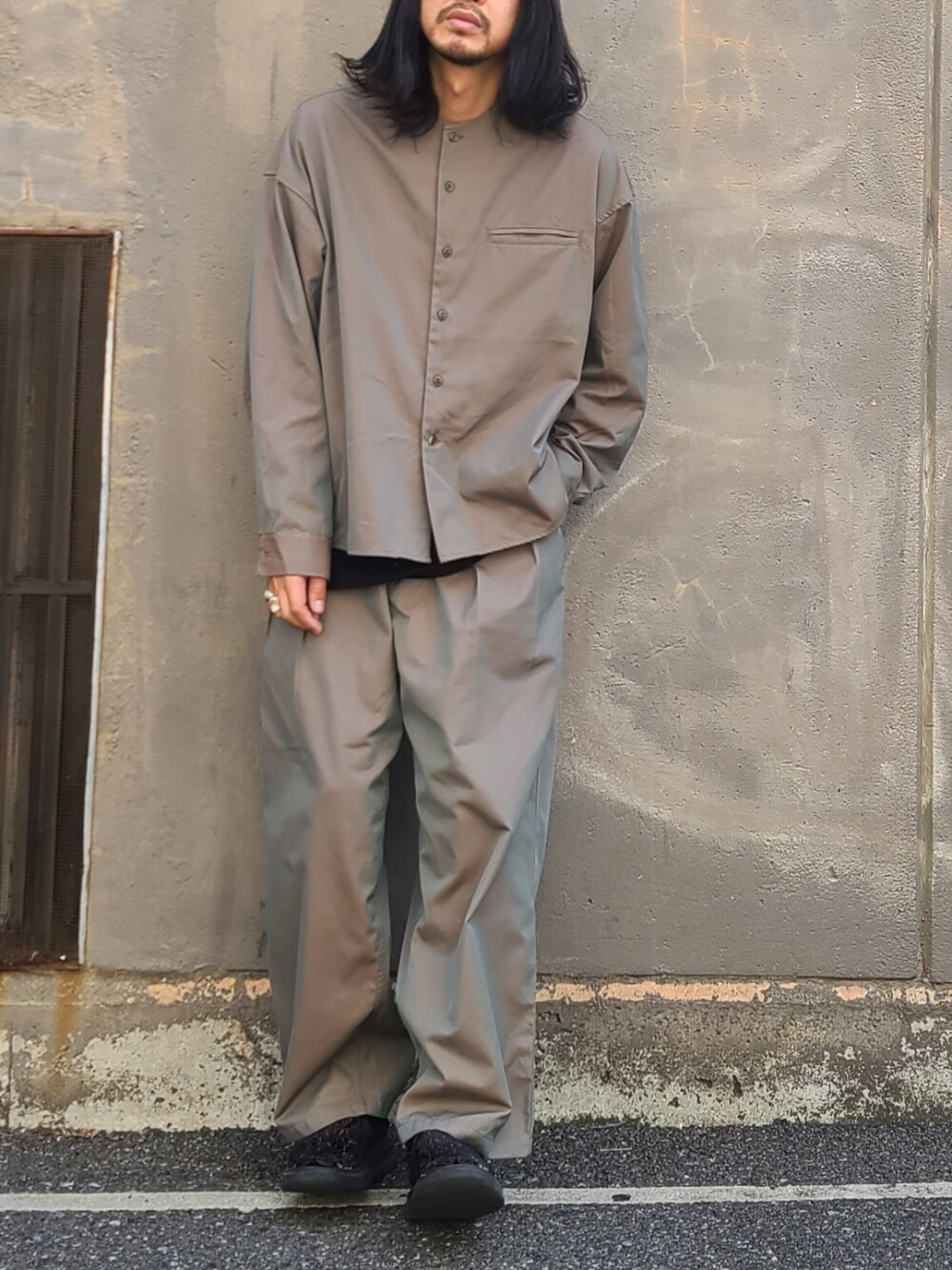 グリーン系のノーカラージャケット、グリーン系のパンツ、シルバー系のリングを着用したメンズの春コーディネートの3枚目の写真