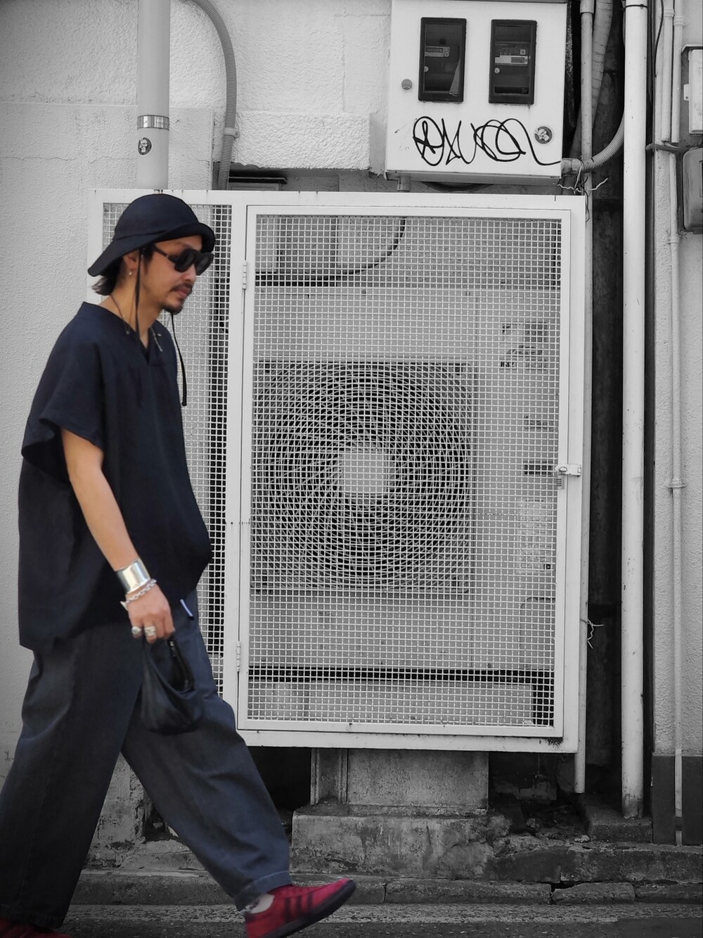 ブラック系のTシャツ/カットソー、ブラック系のデニムパンツ、ブラック系のボディバッグ/ウエストポーチを着用したメンズの春コーディネートの2枚目の写真