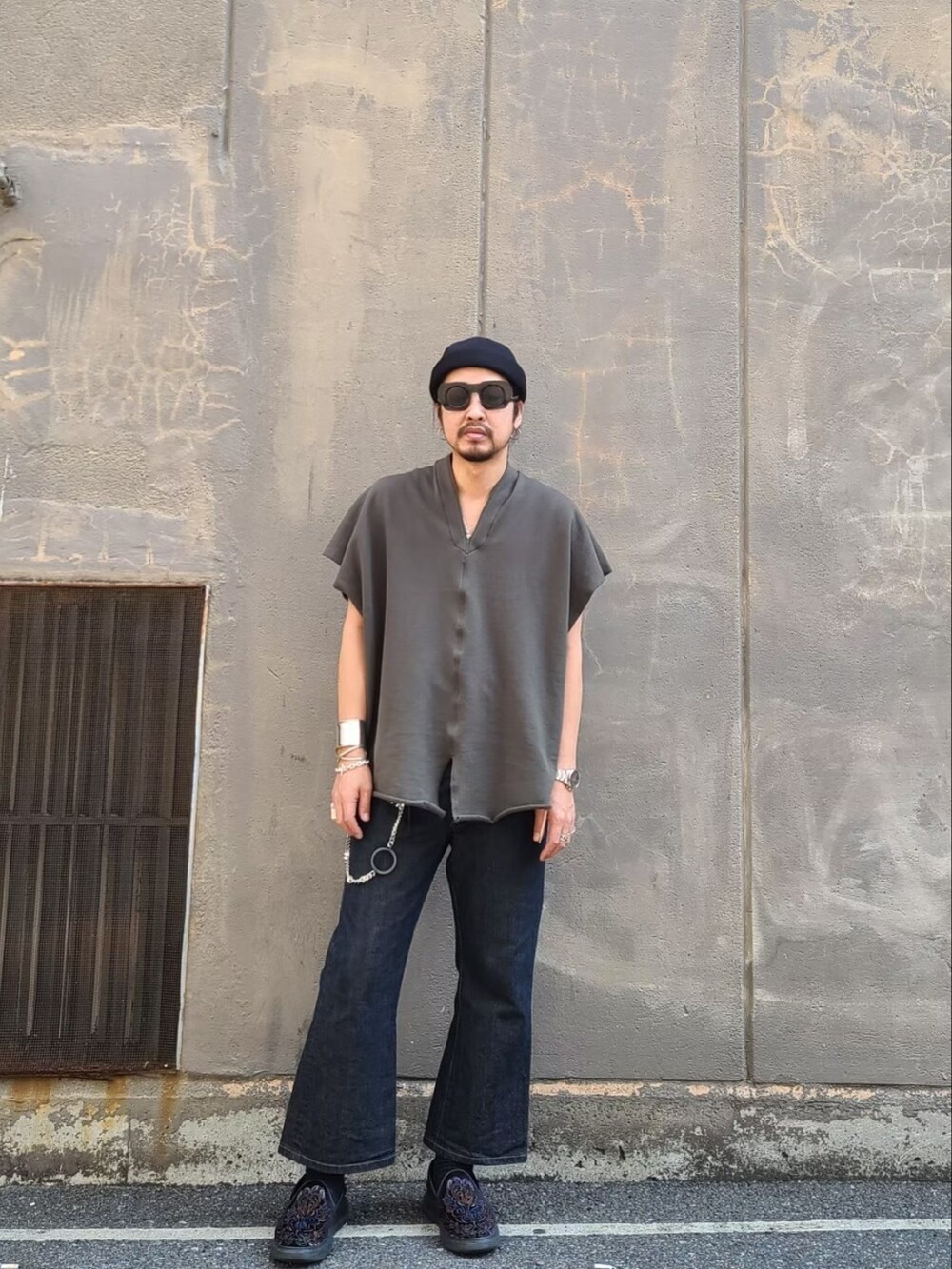 グリーン系のTシャツ/カットソー、ブルー系のデニムパンツ、ブラック系の帽子を着用したメンズの夏コーディネートの2枚目の写真