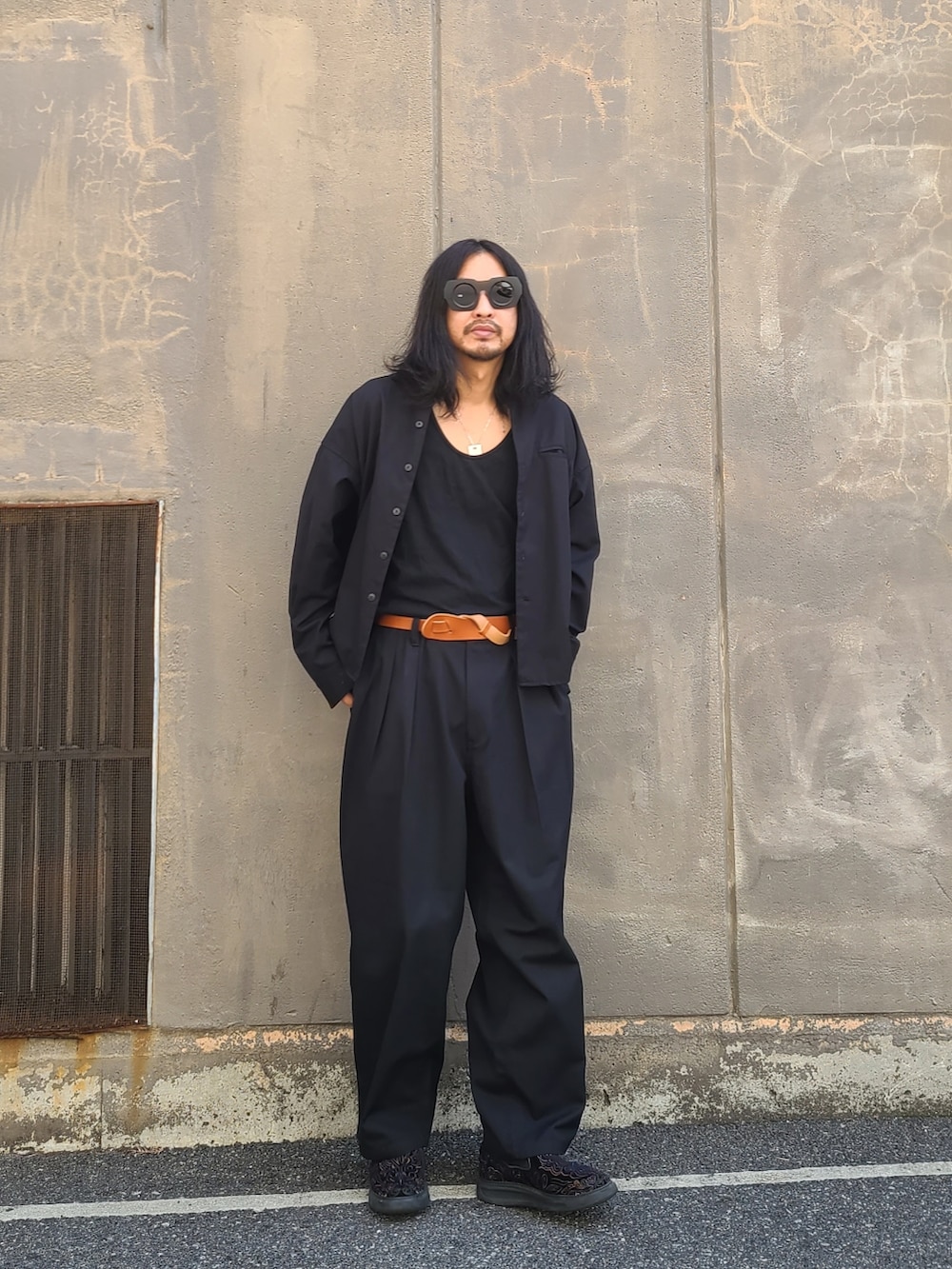 ブラック系のノーカラージャケット、ブラック系のパンツを着用したメンズの春コーディネートの2枚目の写真