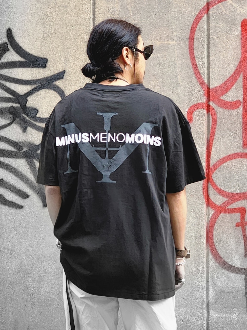 ブラック系のTシャツ/カットソー、ホワイト系のパンツ、ブラウン系のネックレスを着用したメンズの春コーディネートの2枚目の写真