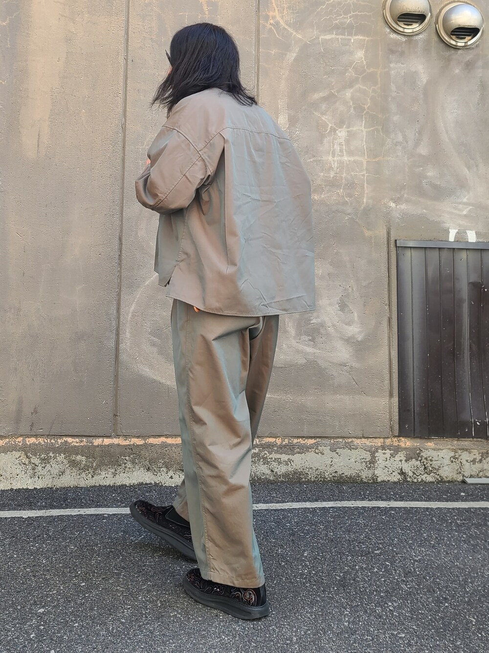 グリーン系のノーカラージャケット、グリーン系のパンツ、シルバー系のリングを着用したメンズの春コーディネートの2枚目の写真