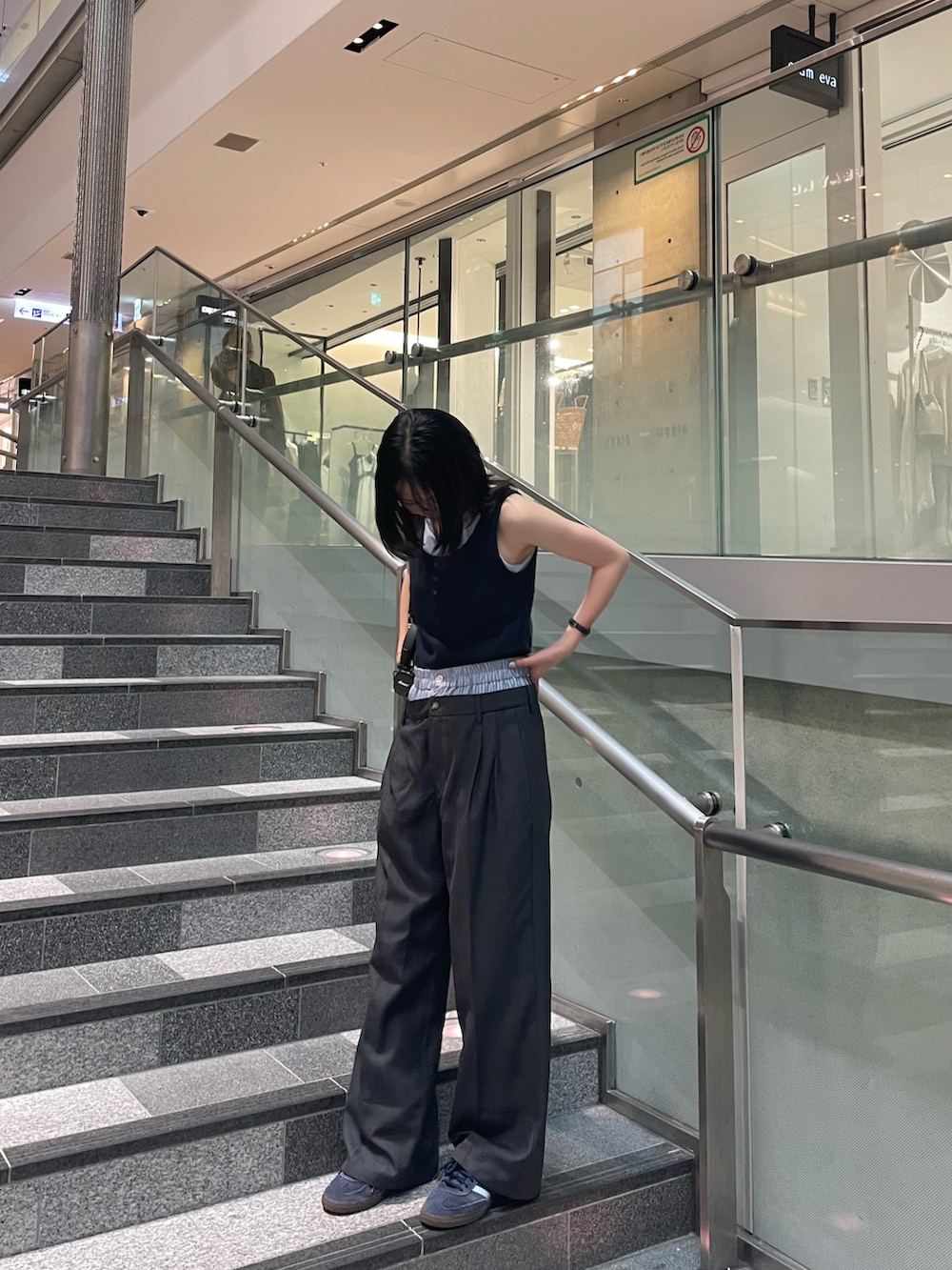 ブルー系のタンクトップ、グレー系のスラックス、ブルー系のスニーカーを着用したレディースの夏コーディネートの2枚目の写真