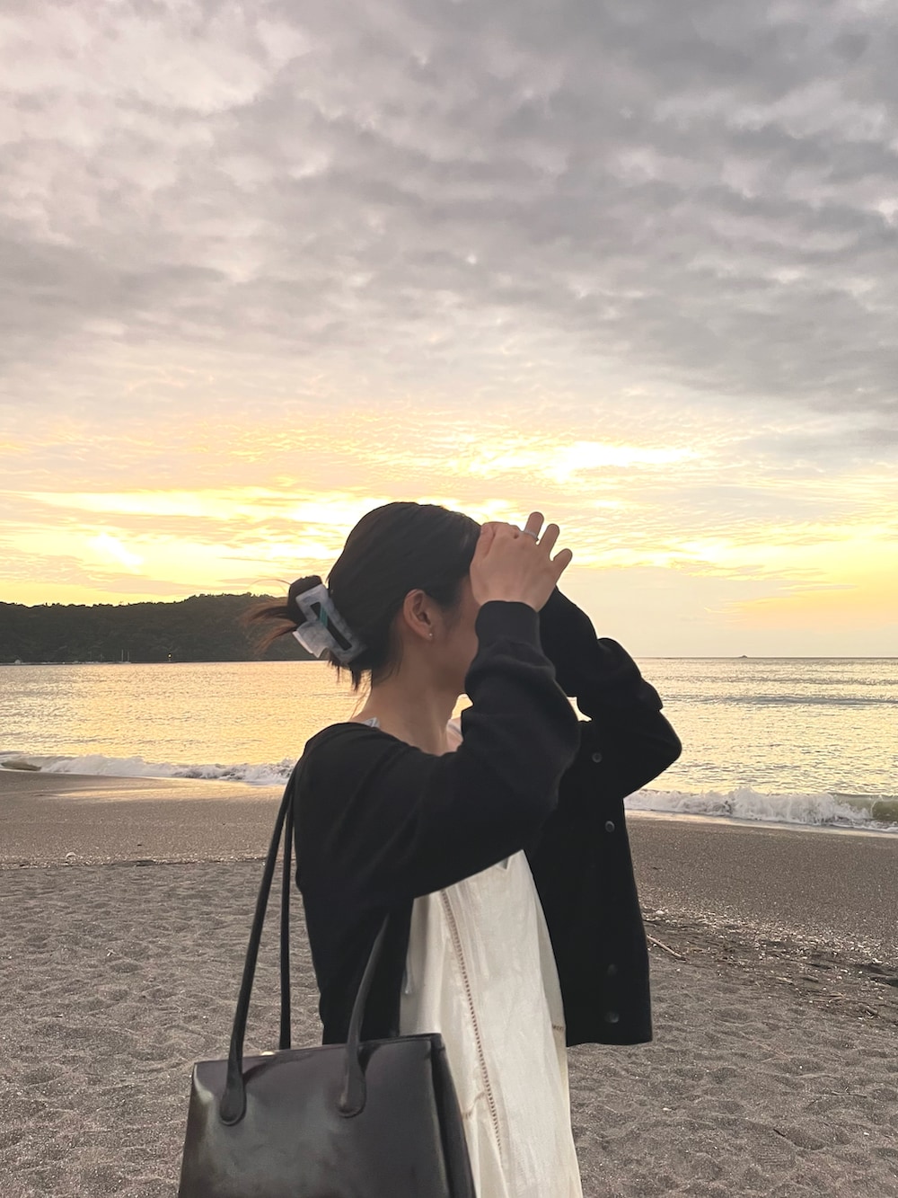 グレー系のスウェットパンツ、ホワイト系のチュニック、シルバー系のサンダルを着用したレディースの秋コーディネートの4枚目の写真