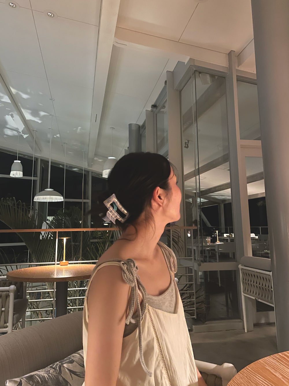 グレー系のスウェットパンツ、ホワイト系のチュニック、シルバー系のサンダルを着用したレディースの秋コーディネートの5枚目の写真