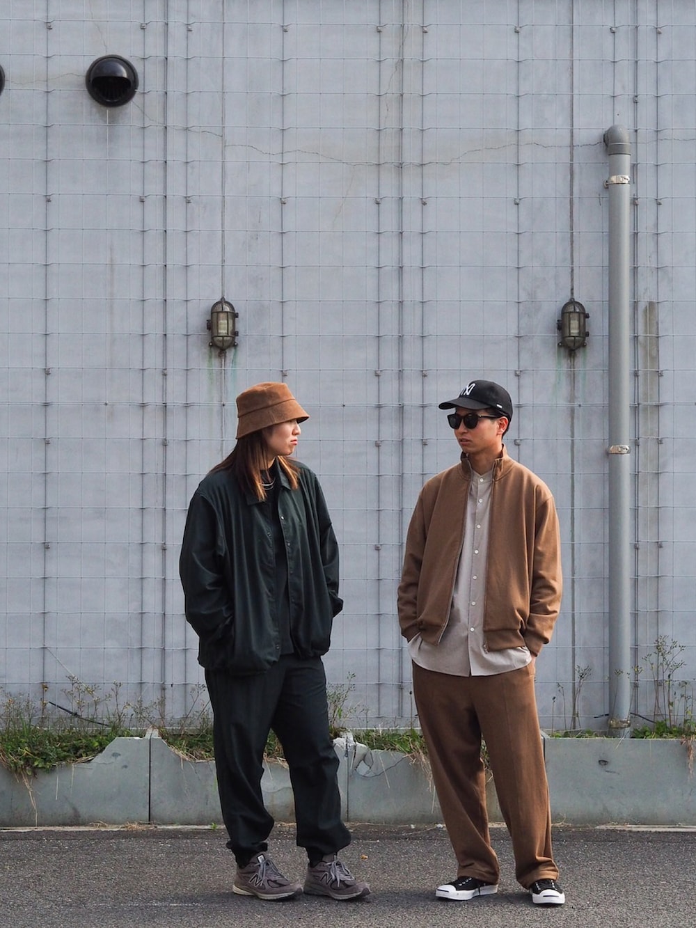 ベージュ系のジャケット/アウター、ブラック系のスニーカー、ブラック系のキャップを着用したメンズの夏コーディネートの2枚目の写真