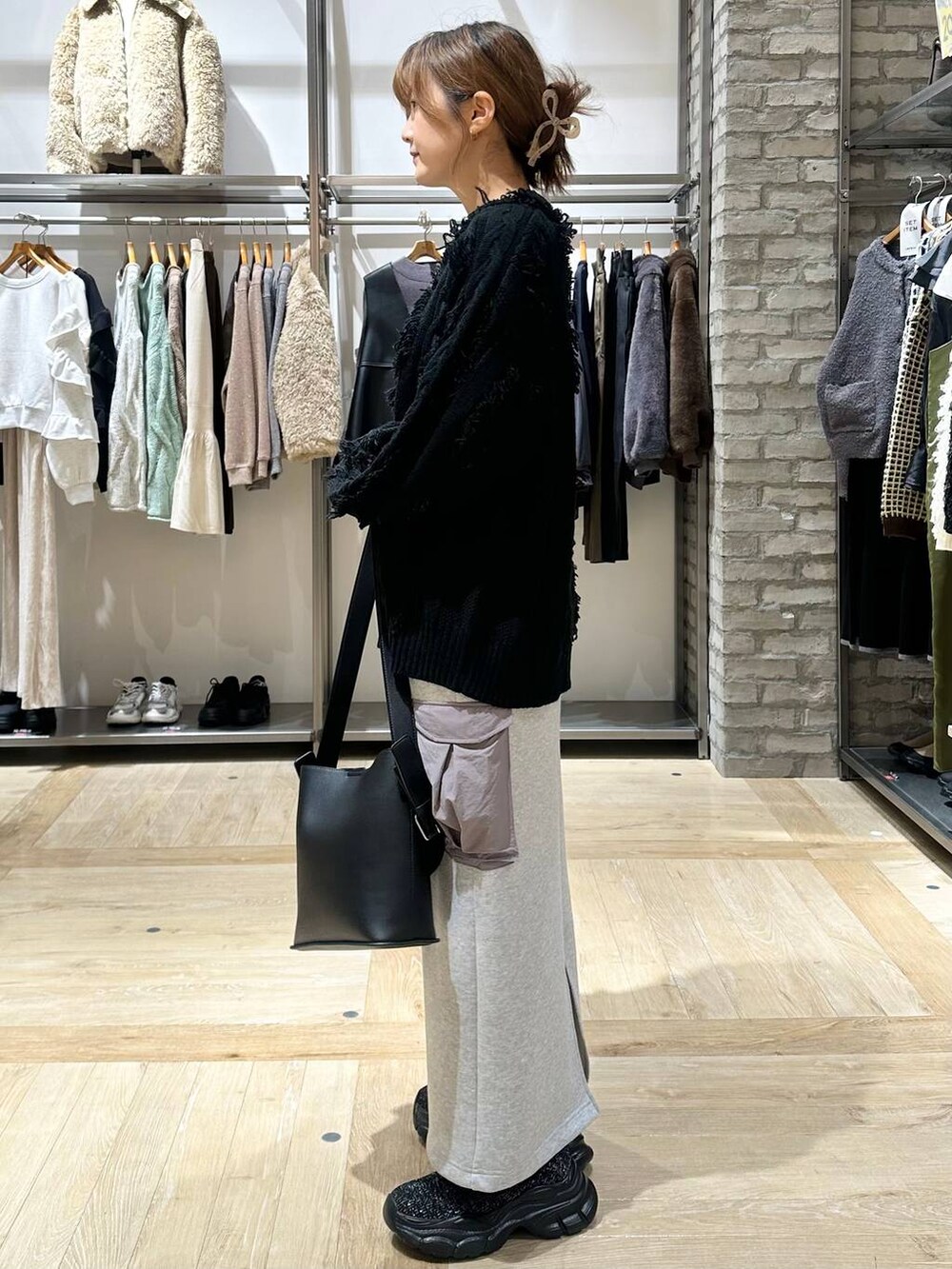 ブラック系のその他アウター、グレー系のスカート、ブラック系のショルダーバッグを着用したレディースの秋コーディネートの2枚目の写真