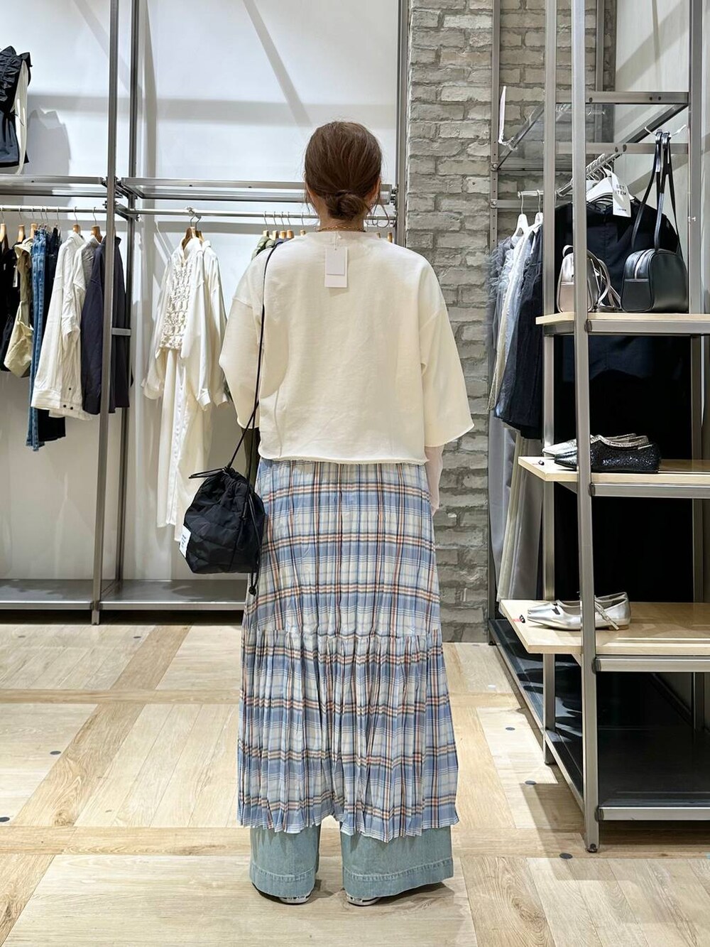 ホワイト系のTシャツ/カットソー、ブラック系のショルダーバッグ、ブルー系のデニムパンツを着用したレディースの春コーディネートの3枚目の写真