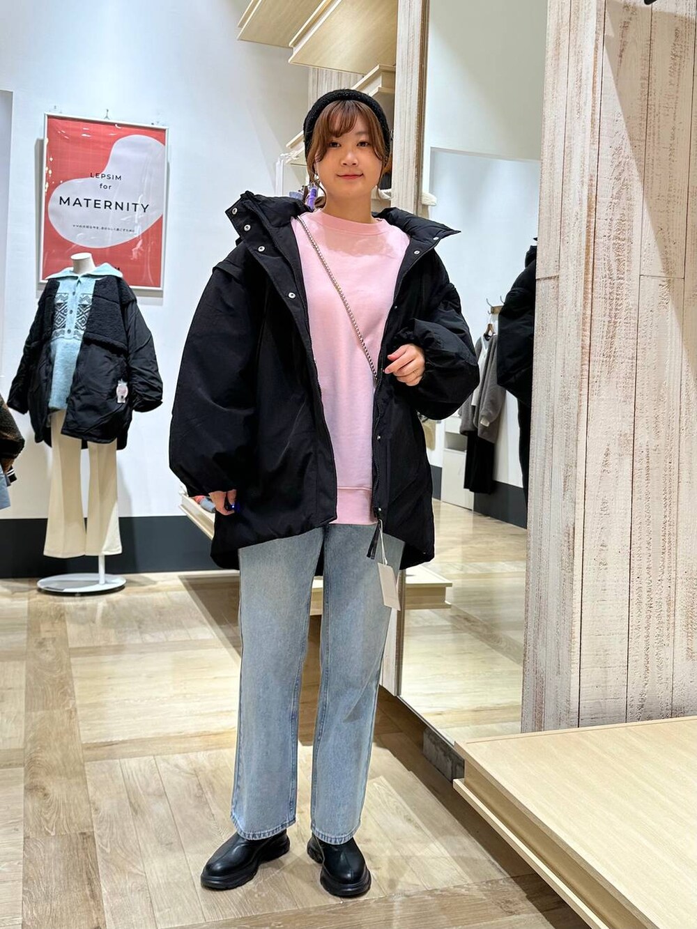 ブラック系のダウンジャケット/コート、ブルー系のデニムパンツ、ブラック系のブーツを着用したレディースの冬コーディネートの2枚目の写真