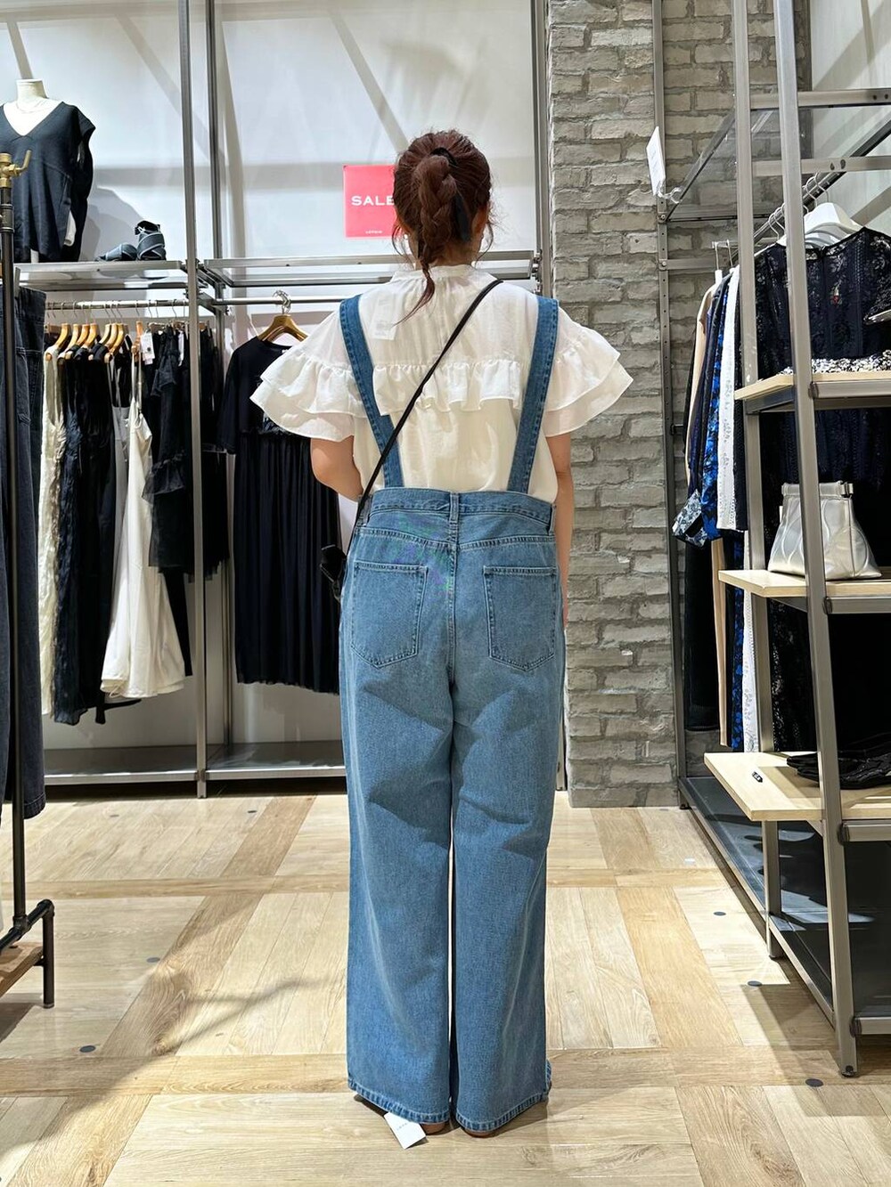 ブラック系のショルダーバッグ、ホワイト系のシャツ/ブラウス、ブルー系のデニムパンツを着用したレディースの夏コーディネートの3枚目の写真