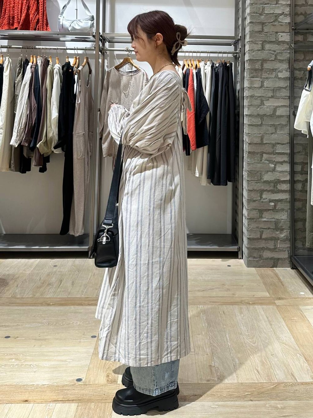 ブラック系のショルダーバッグ、ホワイト系のワンピース、ブラック系のその他シューズを着用したレディースの春コーディネートの3枚目の写真