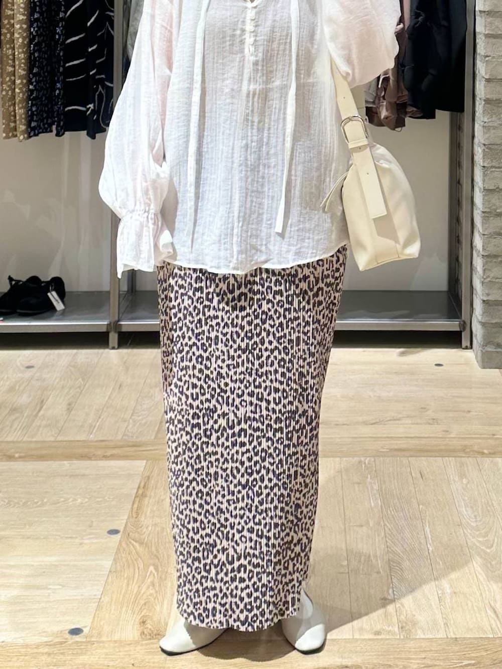 ホワイト系のショルダーバッグ、ホワイト系のパンプス、ホワイト系のシャツ/ブラウスを着用したレディースの春コーディネートの5枚目の写真