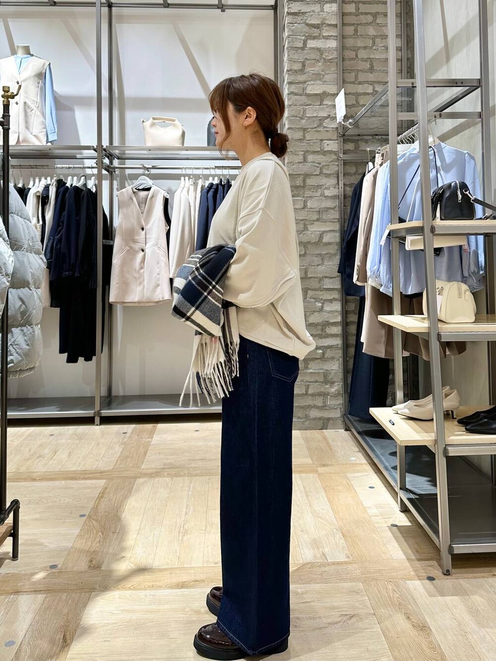 ベージュ系のスウェット、ブラウン系のローファー、ブルー系のデニムパンツを着用したレディースの冬コーディネートの2枚目の写真