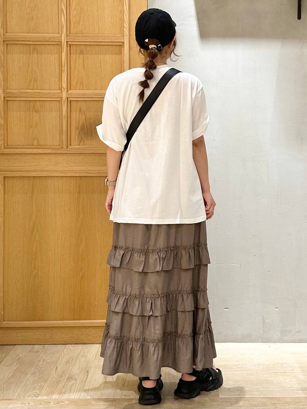 ブラック系のサンダル、ブラウン系のスカート、ブラック系のショルダーバッグを着用したレディースの夏コーディネートの3枚目の写真
