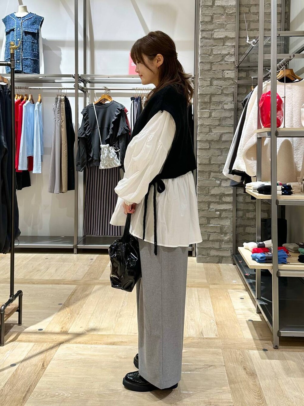 グレー系のその他パンツ、ブラック系のベスト、ブラック系のローファーを着用したレディースの冬コーディネートの2枚目の写真