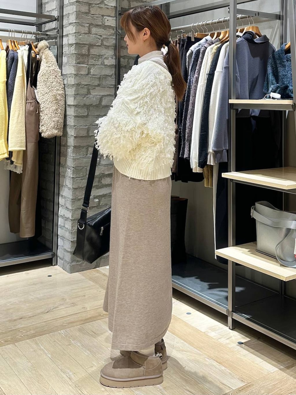 ホワイト系のTシャツ/カットソー、ブラック系のショルダーバッグ、ホワイト系のニット/セーターを着用したレディースの冬コーディネートの3枚目の写真