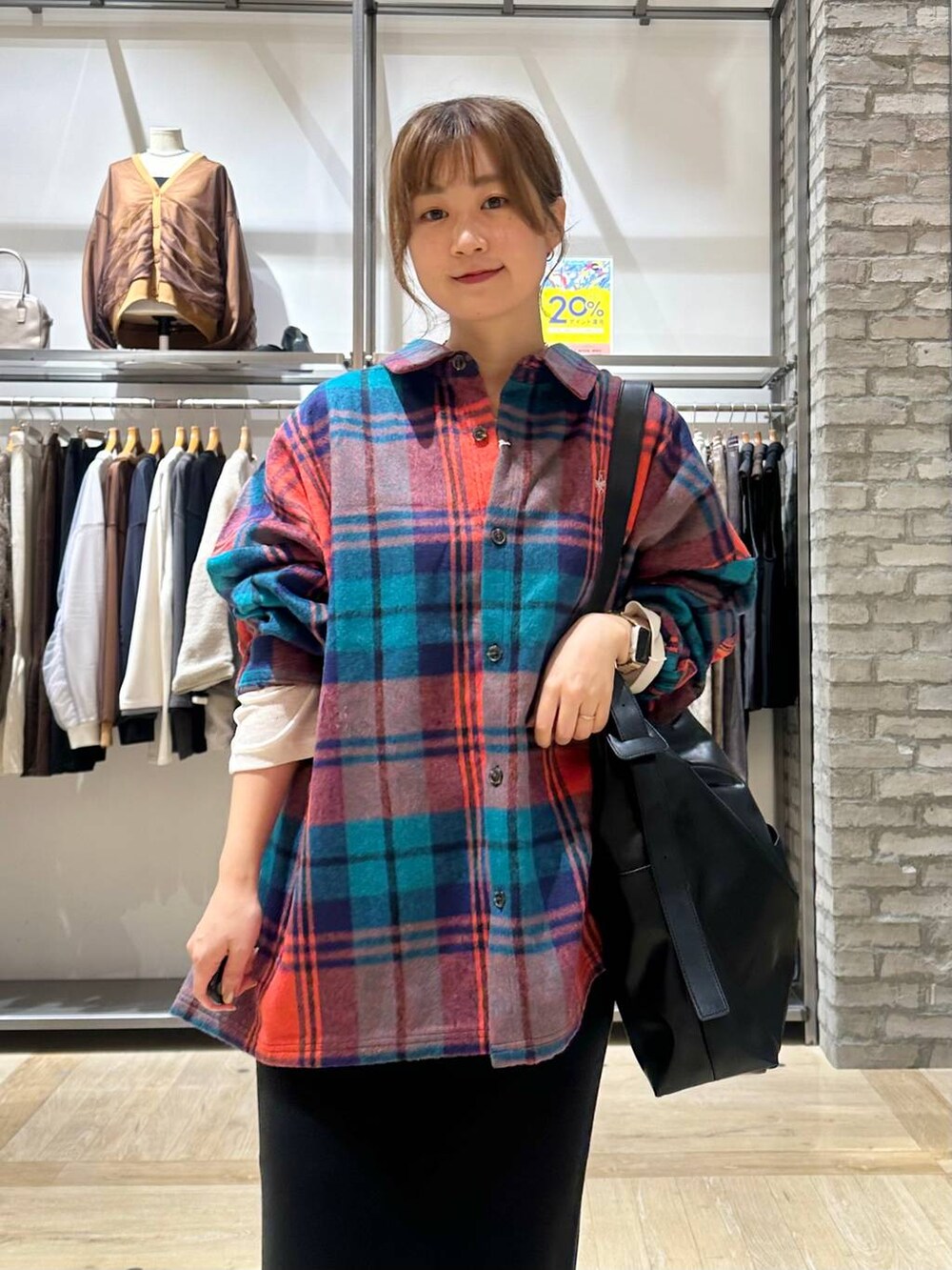 ブラック系のスカート、ホワイト系のスニーカー、ブラック系のショルダーバッグを着用したレディースの秋コーディネートの4枚目の写真