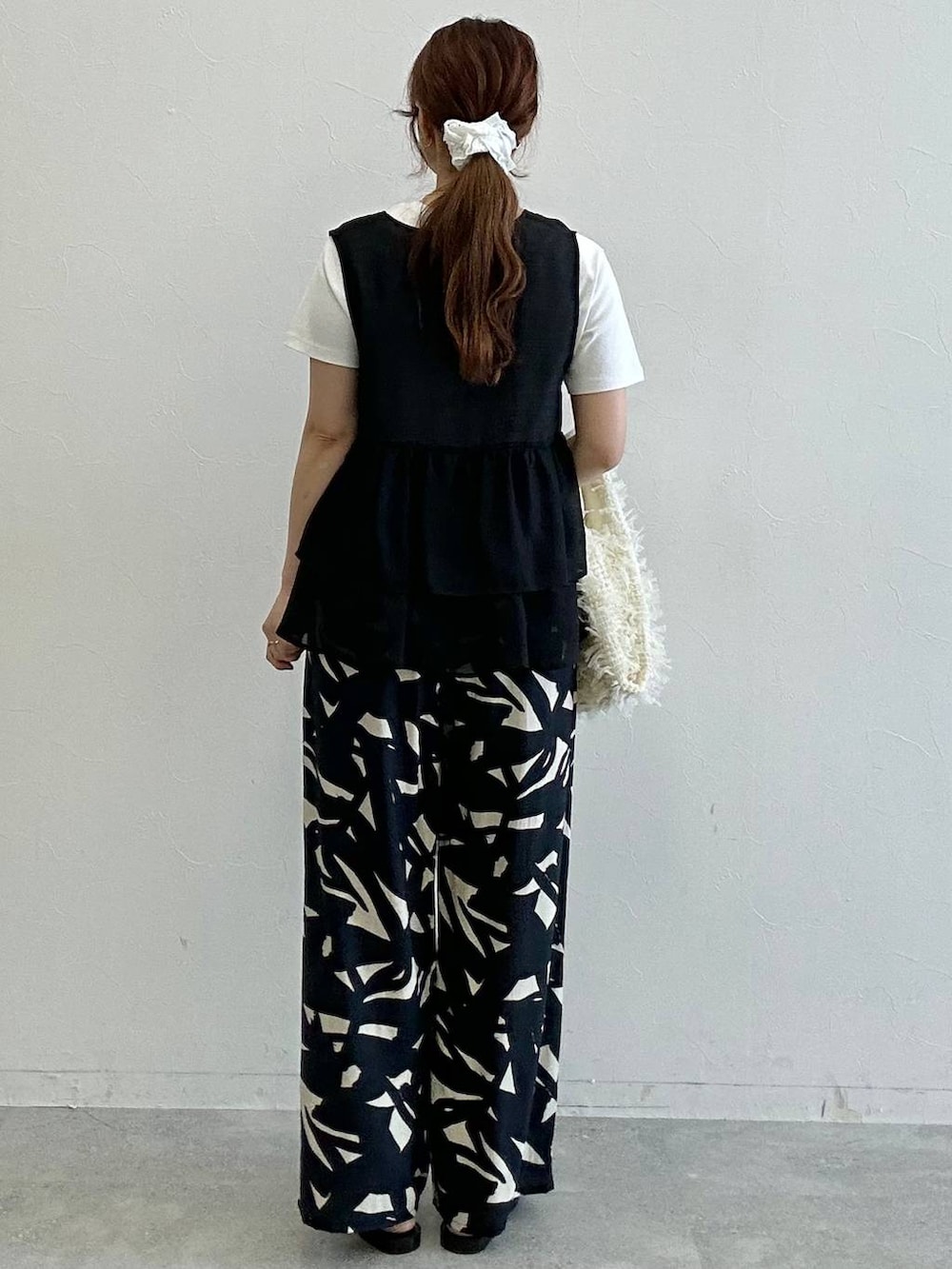 ホワイト系のTシャツ/カットソー、ブラック系のベスト、その他のサンダルを着用したレディースの夏コーディネートの3枚目の写真