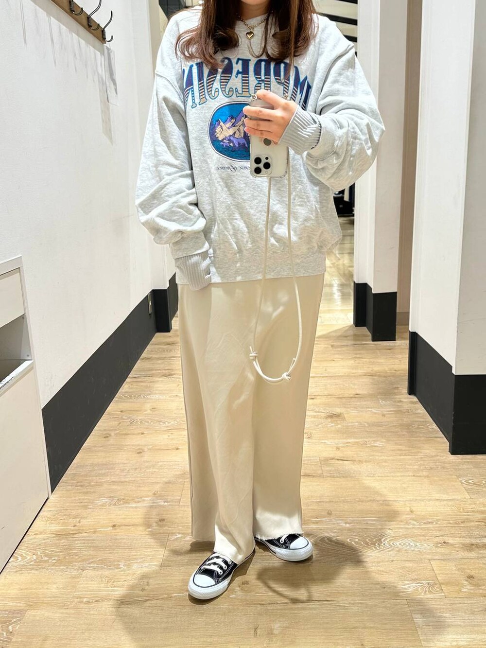 グレー系のTシャツ/カットソー、ホワイト系のスカート、グレー系のスウェットを着用したレディースの冬コーディネートの5枚目の写真