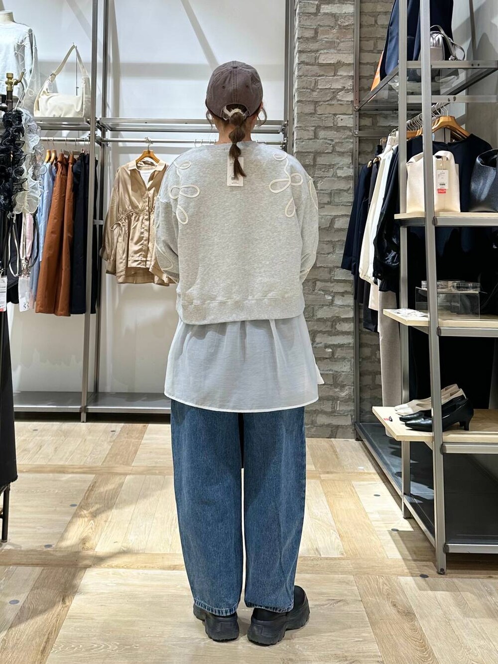 ブラック系のショルダーバッグ、ブラック系のスニーカー、ホワイト系のTシャツ/カットソーを着用したレディースの春コーディネートの3枚目の写真