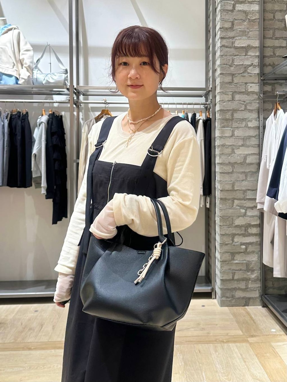 ホワイト系のTシャツ/カットソー、ブラック系のパンプス、ブラック系のトートバッグを着用したレディースの春コーディネートの4枚目の写真