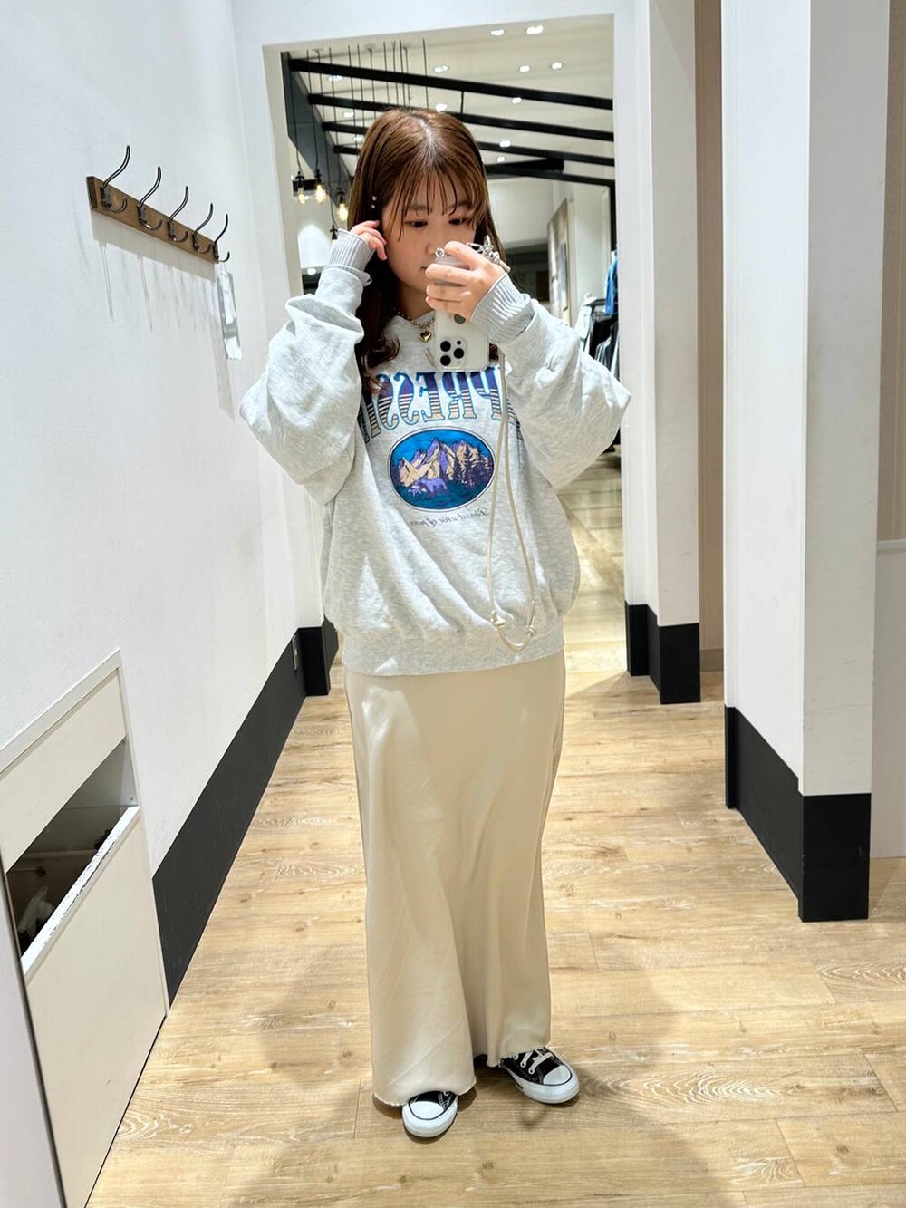 グレー系のTシャツ/カットソー、ホワイト系のスカート、グレー系のスウェットを着用したレディースの冬コーディネートの2枚目の写真