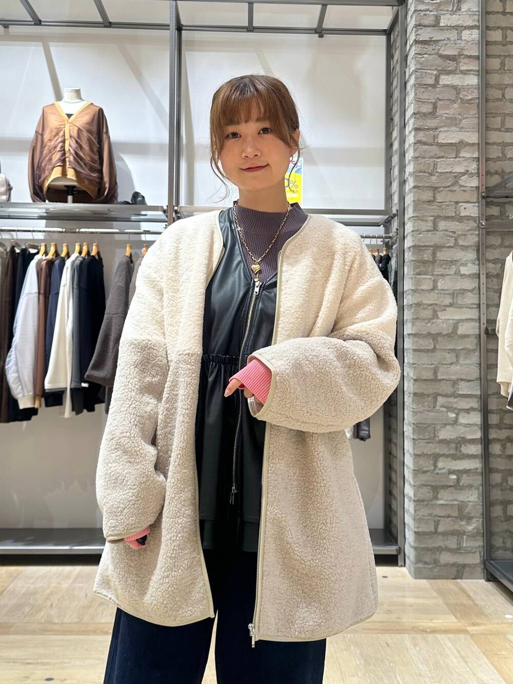 ブルー系のデニムパンツ、グレー系のニット/セーター、ホワイト系のスニーカーを着用したレディースの秋コーディネートの5枚目の写真