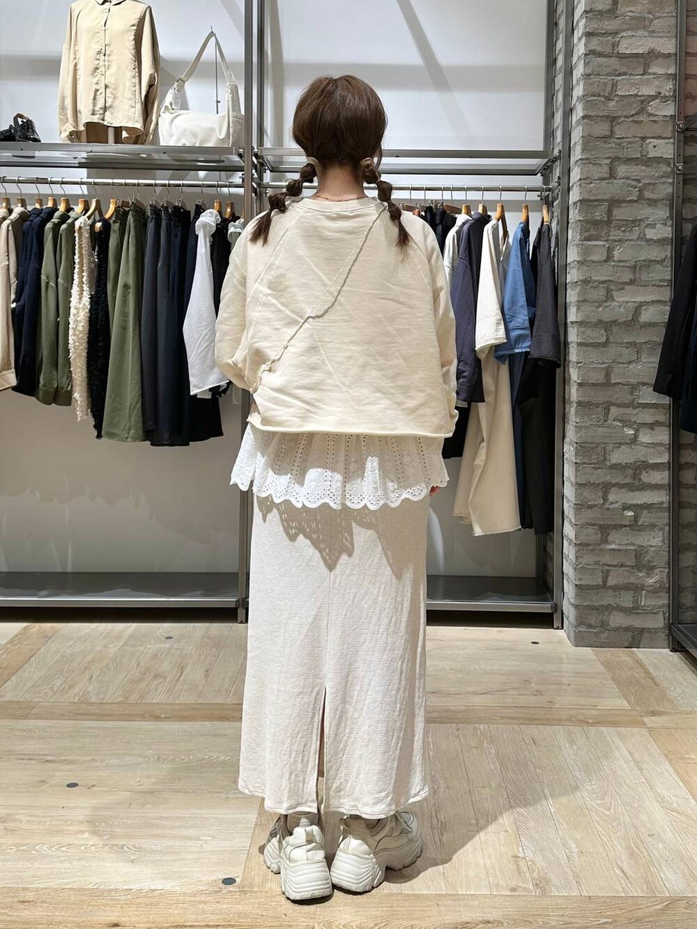 ホワイト系のTシャツ/カットソー、ホワイト系のスカート、ホワイト系のスニーカーを着用したレディースの春コーディネートの3枚目の写真