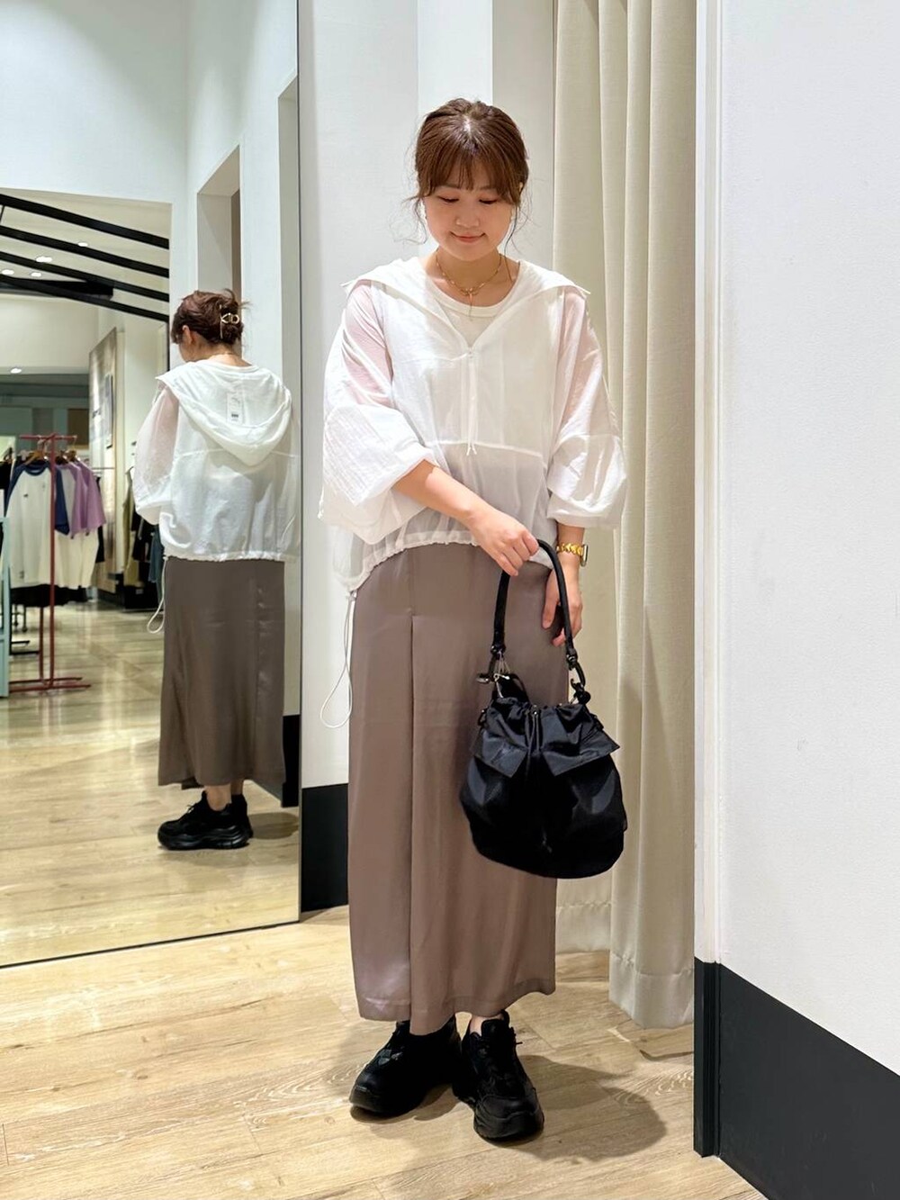 ブラック系のショルダーバッグ、ブラック系のスニーカー、ホワイト系のタンクトップを着用したレディースの秋コーディネートの2枚目の写真