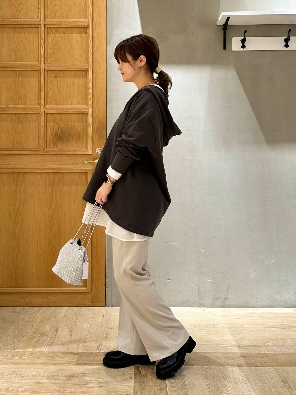 シルバー系のショルダーバッグ、グレー系のチュニック、ブラック系のブーツを着用したレディースの秋コーディネートの2枚目の写真