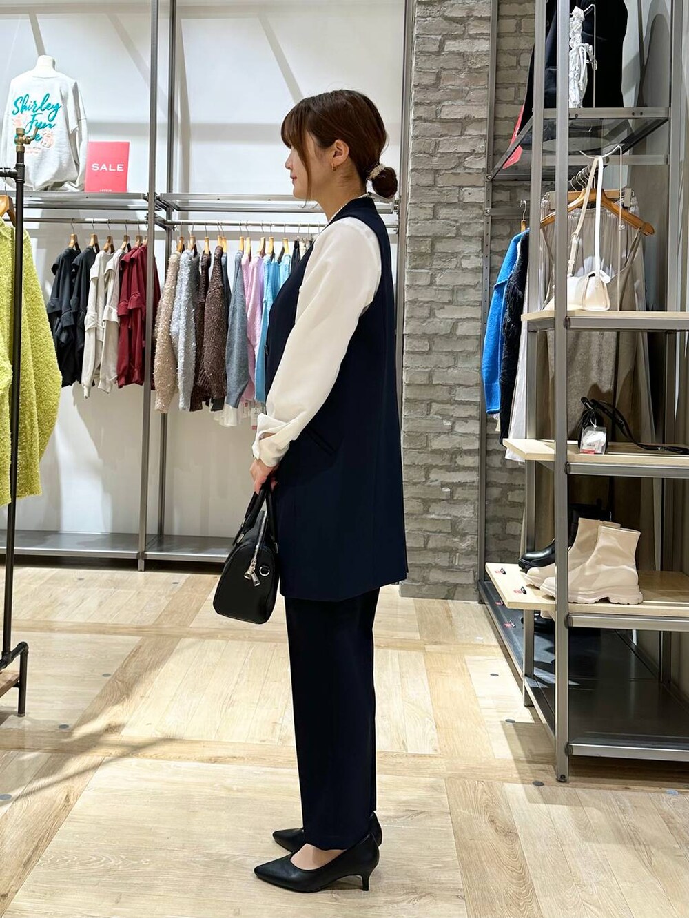 ブルー系のスーツパンツ、ブルー系のスーツベスト、ホワイト系のシャツ/ブラウスを着用したレディースの冬コーディネートの2枚目の写真