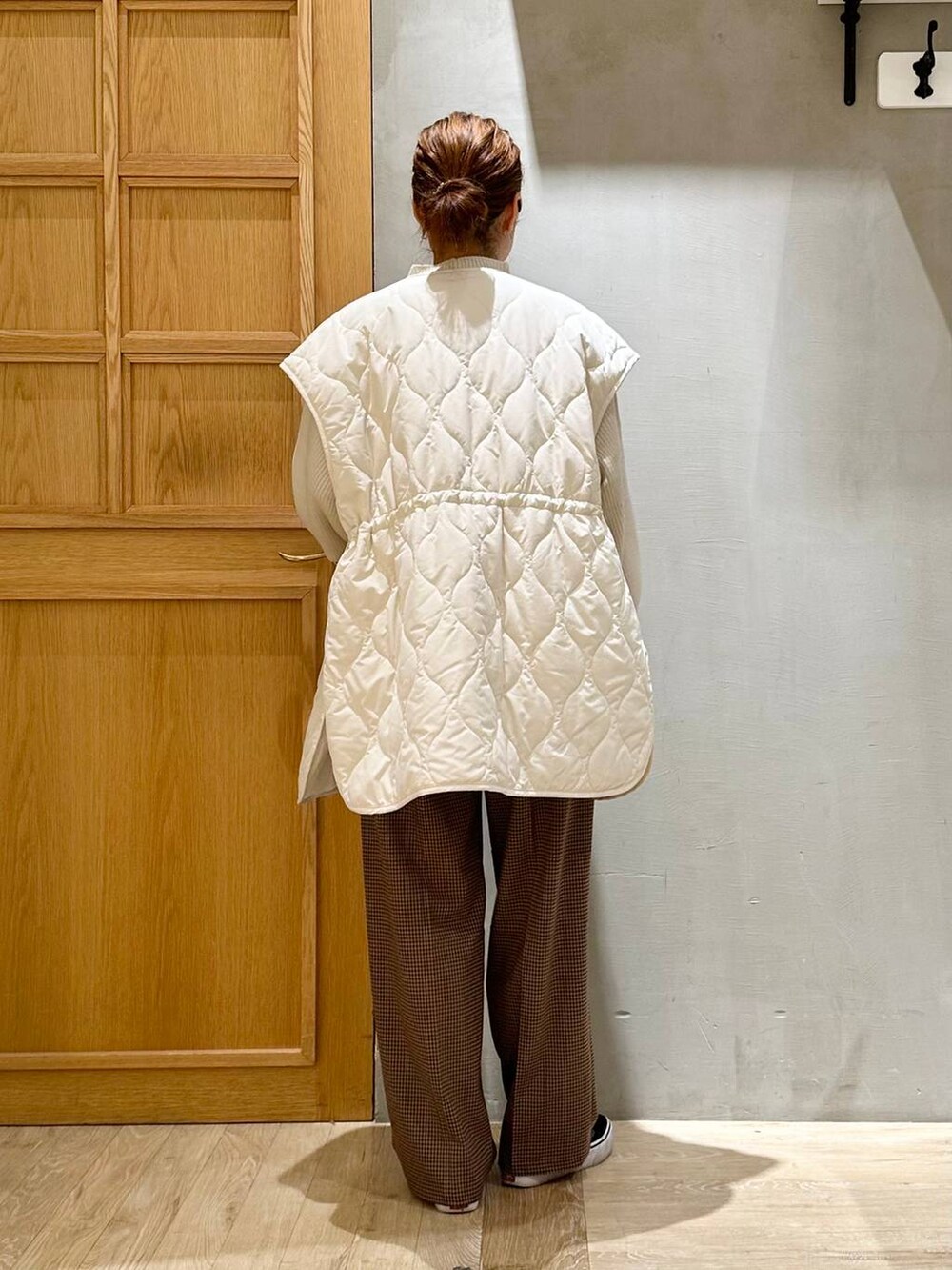 ホワイト系のニット/セーター、ブラック系のショルダーバッグ、ホワイト系のその他アウターを着用したレディースの秋コーディネートの3枚目の写真