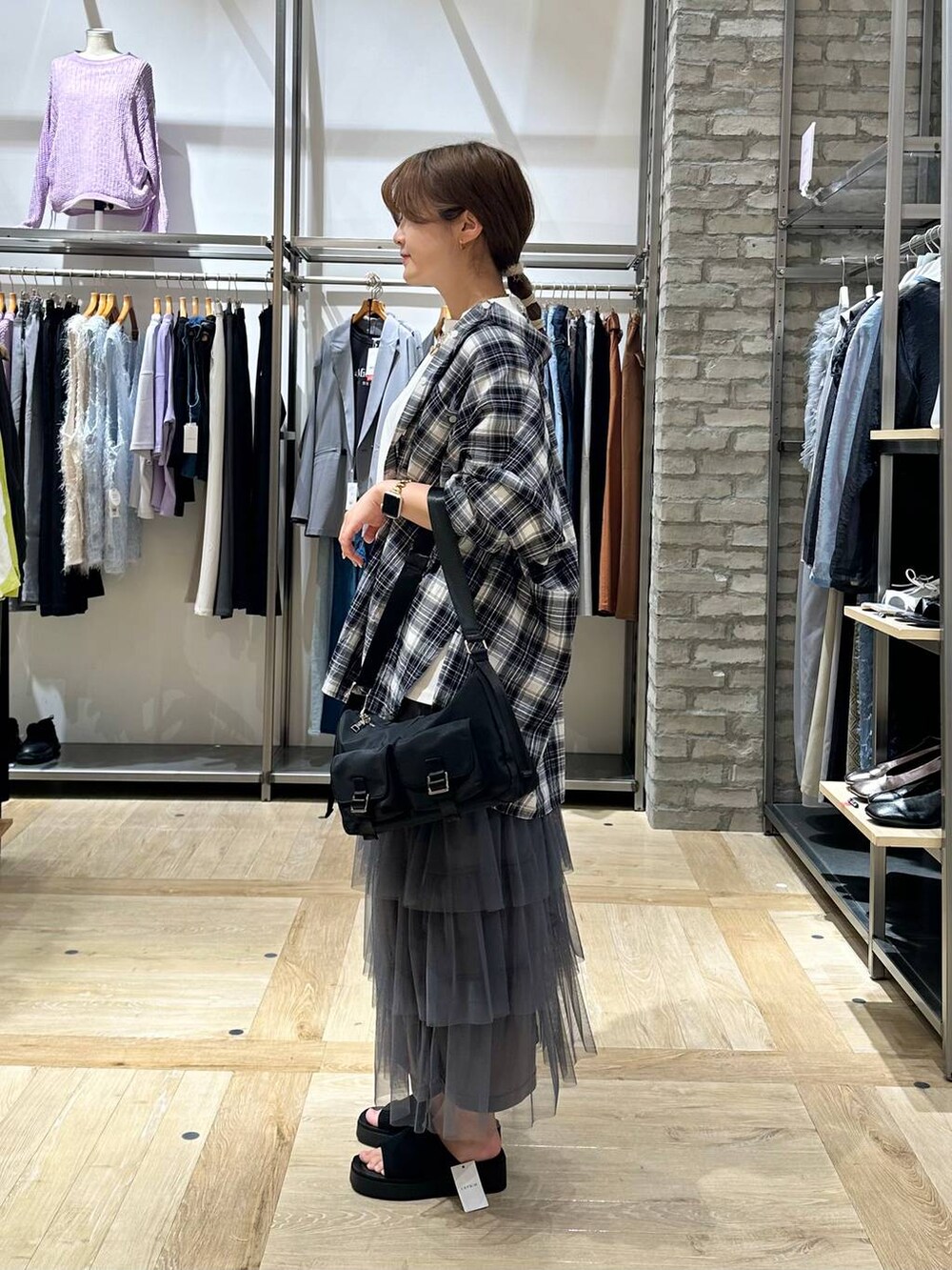 ホワイト系のTシャツ/カットソー、ブラック系のショルダーバッグ、ブラック系のシャツ/ブラウスを着用したレディースの春コーディネートの2枚目の写真