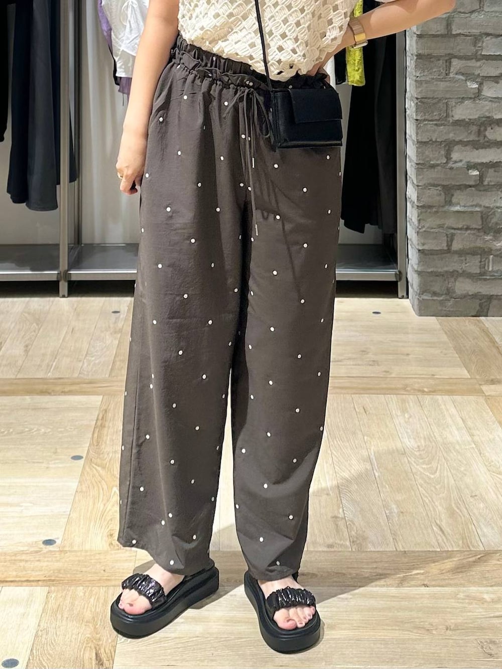 ブラック系のサンダル、ホワイト系のTシャツ/カットソー、ブラウン系のその他パンツを着用したレディースの夏コーディネートの5枚目の写真