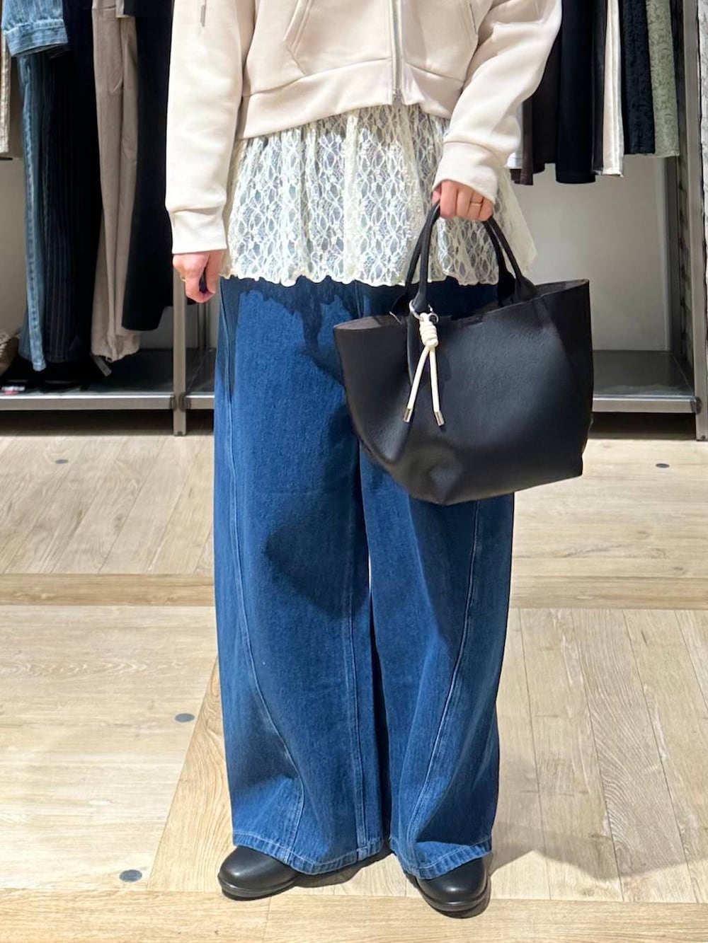 ブラック系のパンプス、ホワイト系のシャツ/ブラウス、ブラック系のトートバッグを着用したレディースの春コーディネートの4枚目の写真