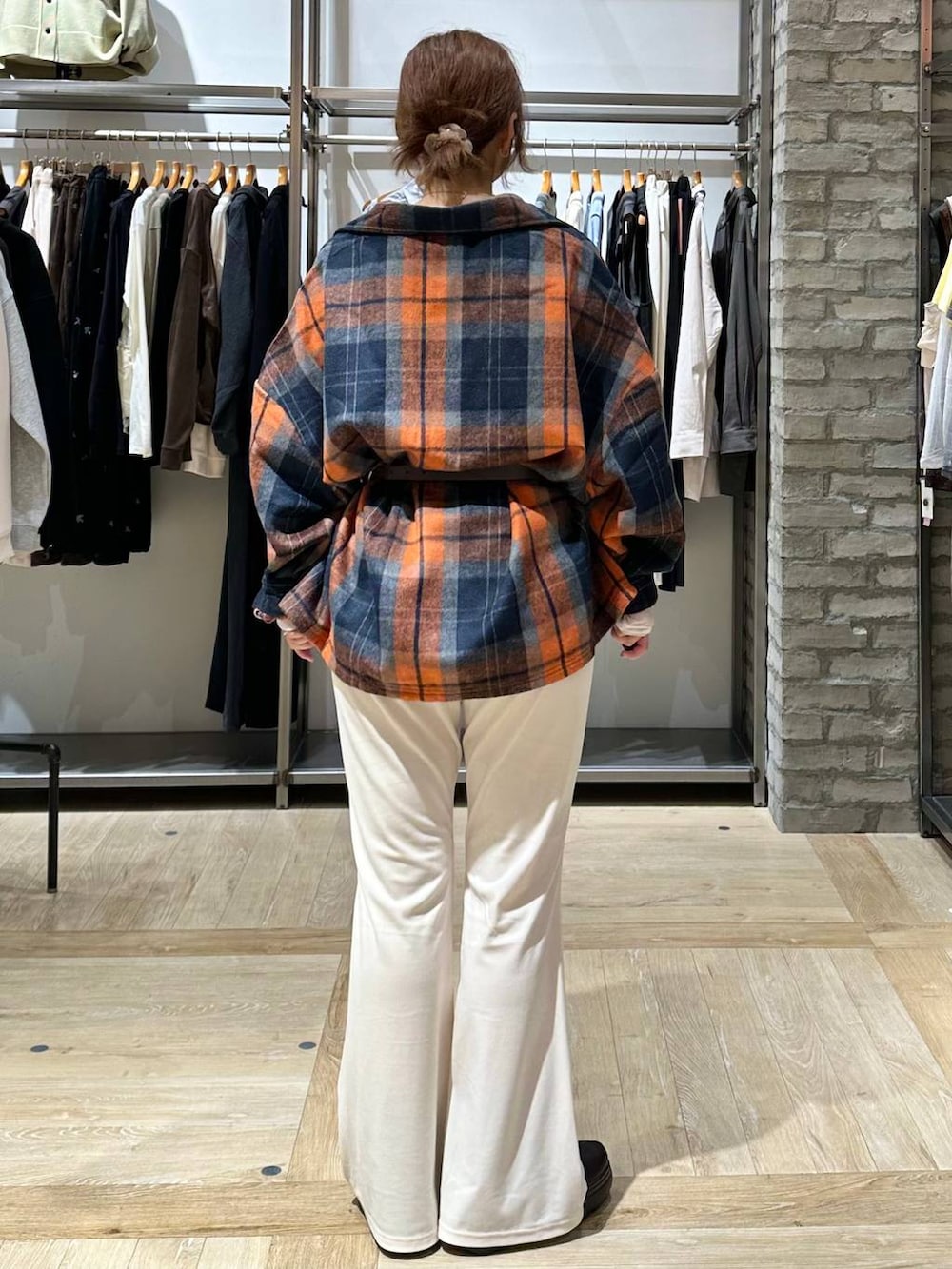 ブラウン系のブーツ、ホワイト系のTシャツ/カットソー、オレンジ系のシャツ/ブラウスを着用したレディースの秋コーディネートの3枚目の写真