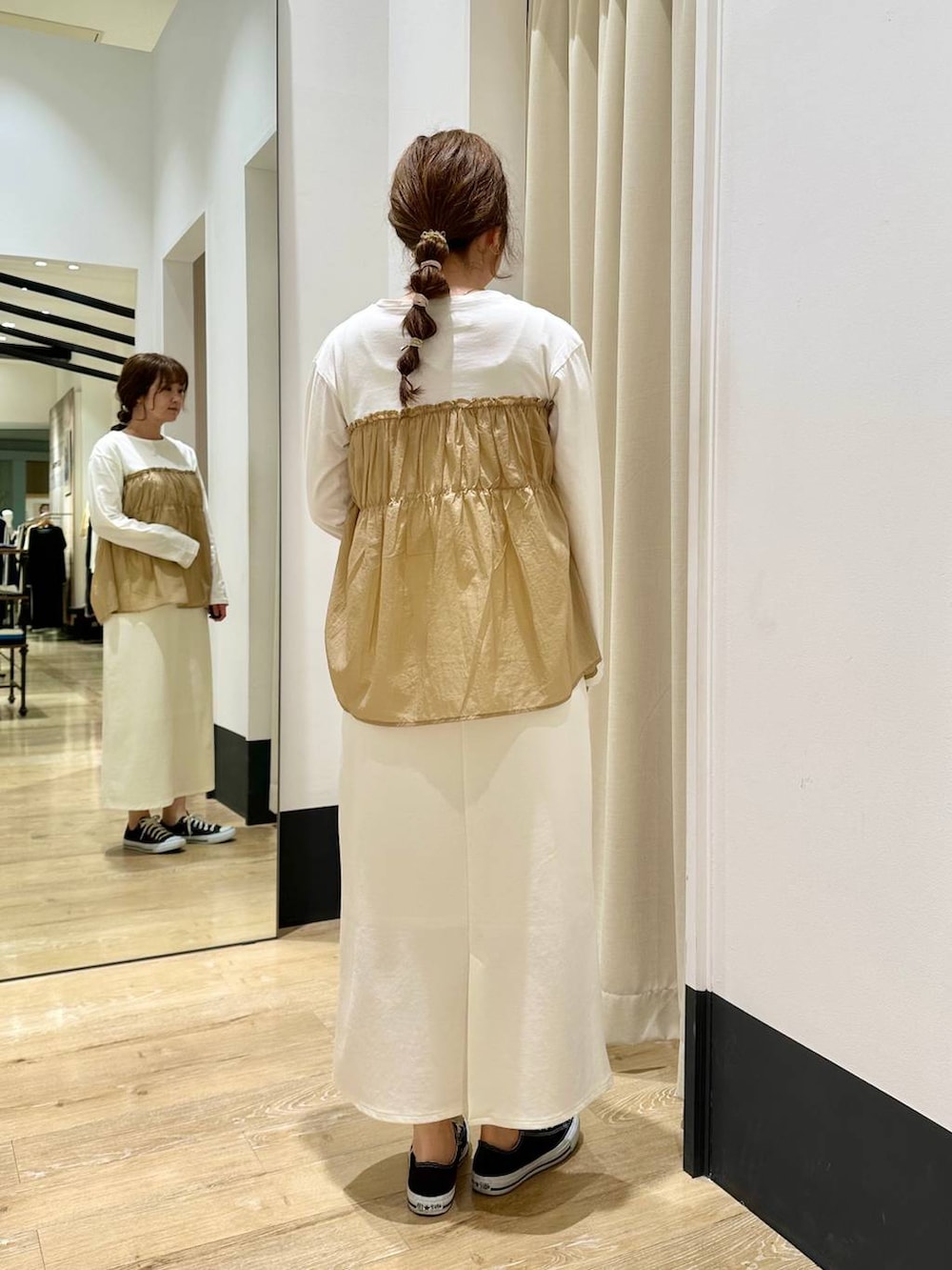 ホワイト系のスカート、ブラック系のショルダーバッグ、ベージュ系のTシャツ/カットソーを着用したレディースの春コーディネートの5枚目の写真