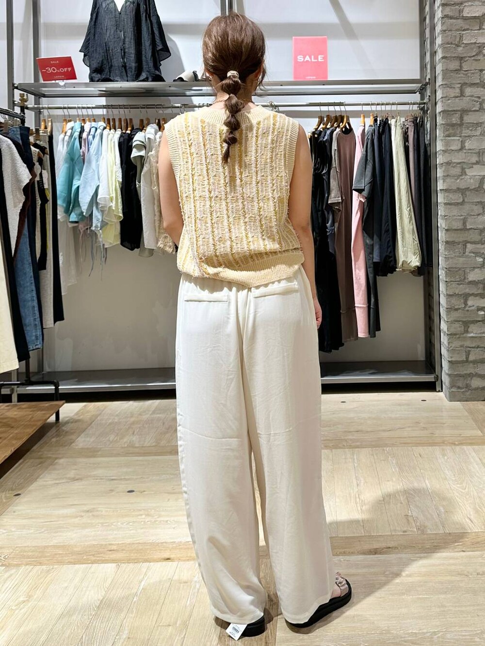 ホワイト系のその他パンツ、ホワイト系のタンクトップ、ベージュ系のサンダルを着用したレディースの夏コーディネートの3枚目の写真