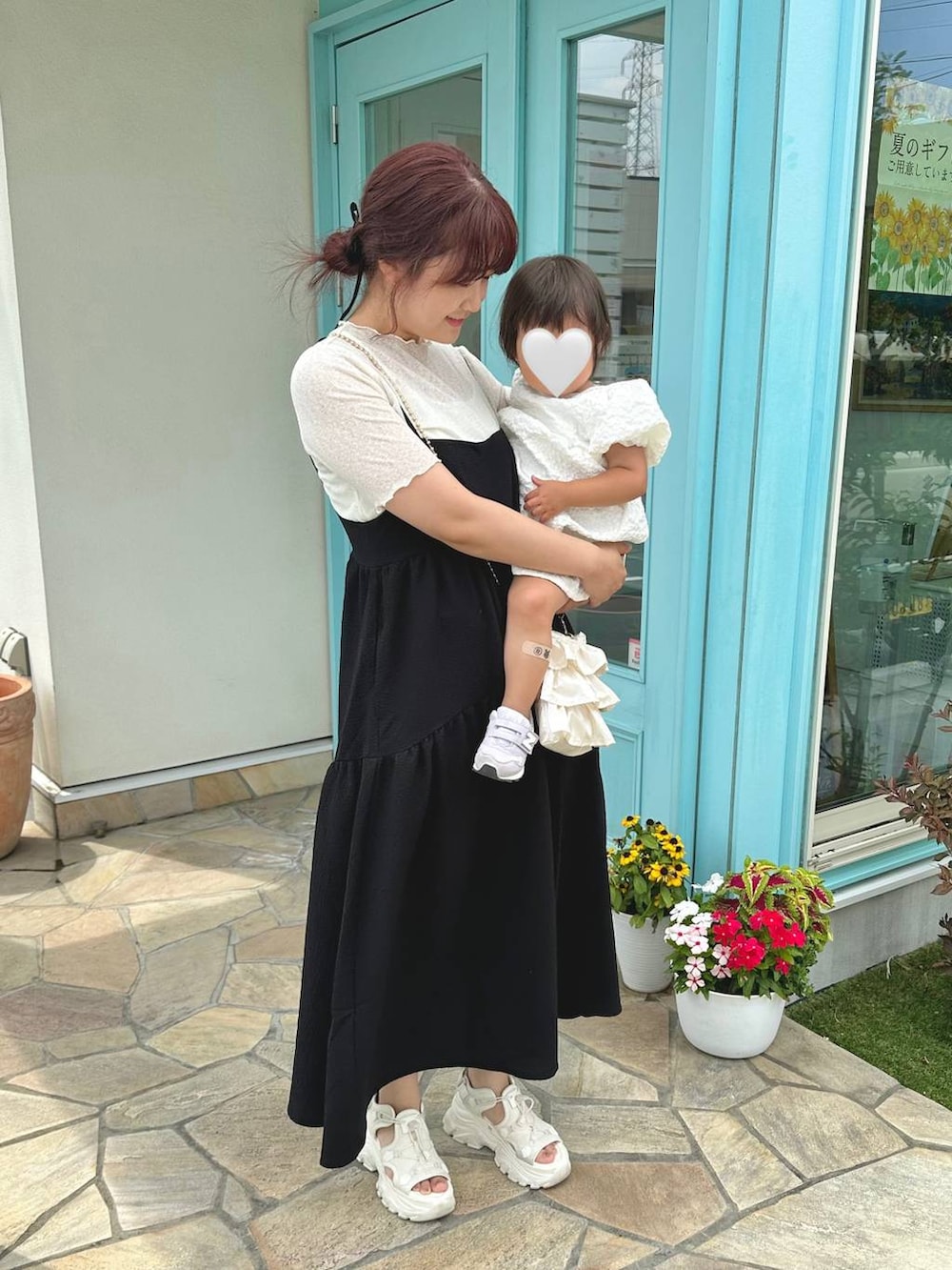 ブラック系のワンピース、ホワイト系のショルダーバッグ、ホワイト系のサンダルを着用したレディースの夏コーディネートの3枚目の写真