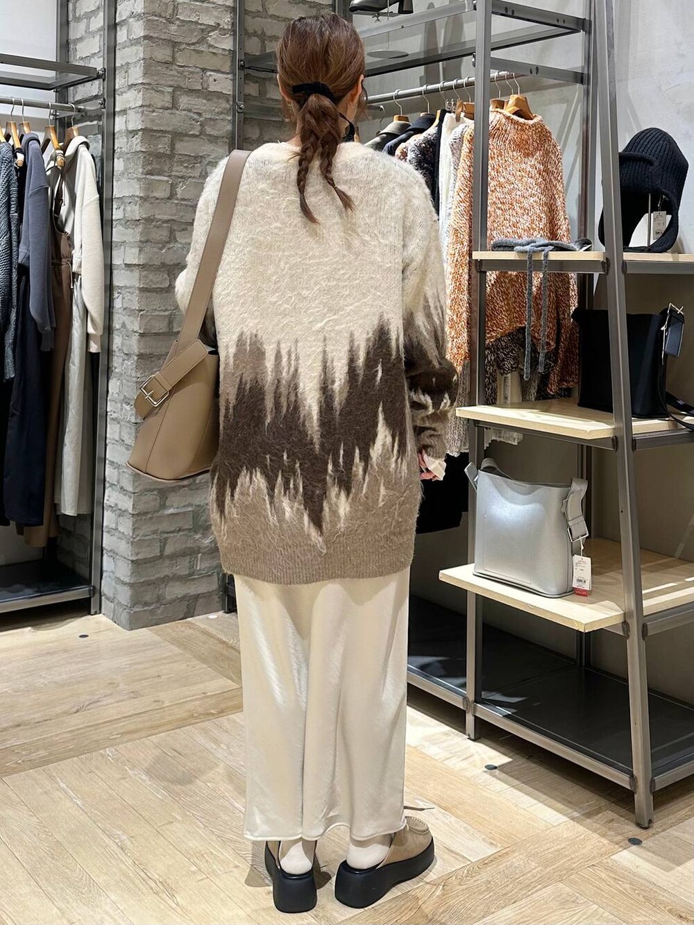 ホワイト系のTシャツ/カットソー、ホワイト系のスカート、ブラウン系のショルダーバッグを着用したレディースの冬コーディネートの4枚目の写真