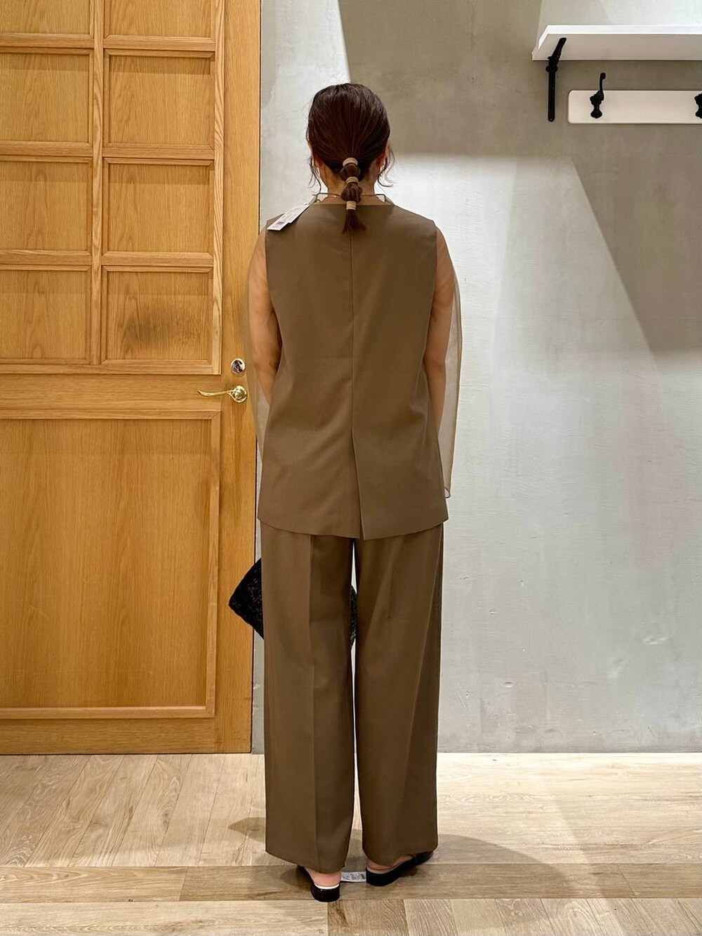 ブラック系のその他シューズ、グリーン系のパンツドレス、ブラック系のハンドバッグを着用したレディースの秋コーディネートの3枚目の写真