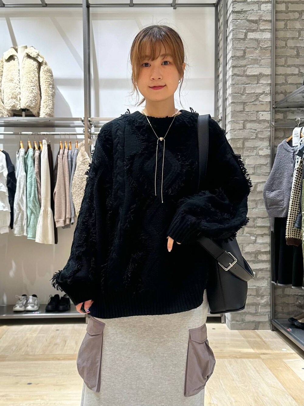 ブラック系のその他アウター、グレー系のスカート、ブラック系のショルダーバッグを着用したレディースの秋コーディネートの4枚目の写真