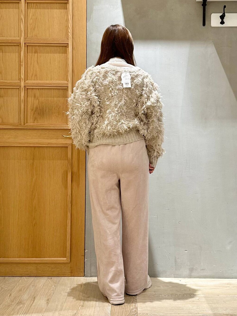 ホワイト系のTシャツ/カットソー、ホワイト系のブーツ、ホワイト系のカーディガン/ボレロを着用したレディースの冬コーディネートの4枚目の写真